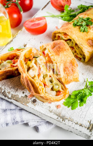 Strudel aux légumes salés faits maison, la cuisson de l'automne, avec des tomates, poivrons, champignons, fond de bois copy space Banque D'Images