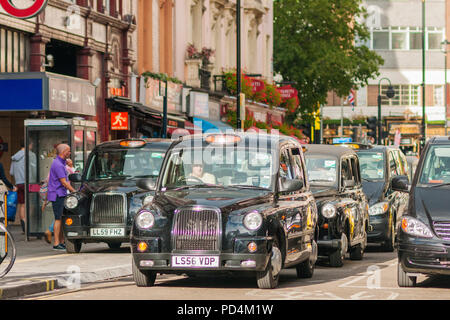 Londres, Royaume-Uni - 12 septembre 2012 des taxis qui attendent le signal vert à un feu rouge près de Leicester Square à Londres. Banque D'Images