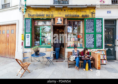 Deux femmes lisant devant la librairie Shakespeare and Company dans le quartier Latin, Paris, France Banque D'Images