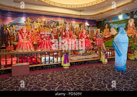 Une femme seule, priant et méditant devant un autel avec des statues de divinités hindoues. Au Mandir Tulsi dans South Richmond Hill Queens. Banque D'Images