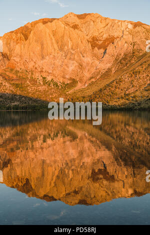 Sunrise jette une lumière dorée sur des pics de montagne reflète dans un lac alpin - Convict Lake dans l'est de la Sierra Nevada de Californie Banque D'Images