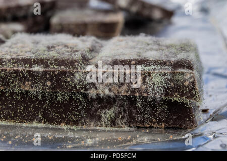 Chocolat moisis dans l'emballage d'origine. Des produits alimentaires utilisés pour les desserts. Arrière-plan blanc. Banque D'Images