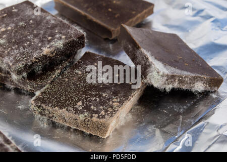 Chocolat moisis dans l'emballage d'origine. Des produits alimentaires utilisés pour les desserts. Arrière-plan blanc. Banque D'Images