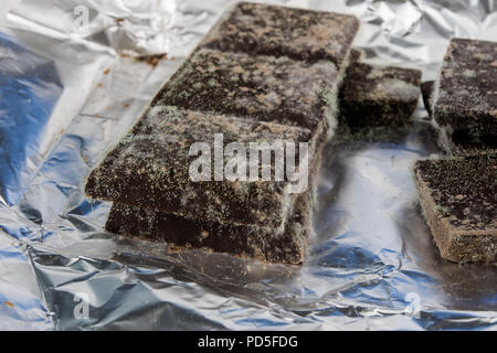 Chocolat moisis dans l'emballage d'origine. Des produits alimentaires utilisés pour les desserts. Arrière-plan blanc. Banque D'Images