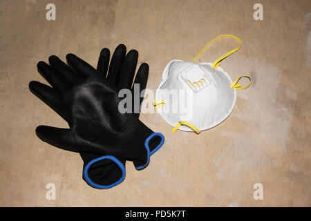 Sécurité travail isolé blanc masque anti-poussière matériel jetable et des gants en caoutchouc noir Banque D'Images