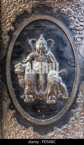 Metal art embossé avec un homme barbu comme un portrait dans un type de fantaisie cadre doré assis sur un animal de dragon. Banque D'Images