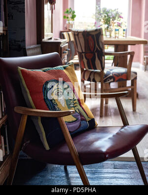 Un coussin jacquard tissé de Picasso représentant Dora Maar du Conran Shop placé sur une chaise au milieu du siècle. Banque D'Images