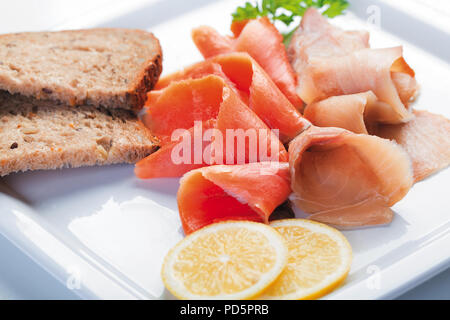 Mélange de rouge et blanc des morceaux de poisson salé sur une plaque blanche Banque D'Images