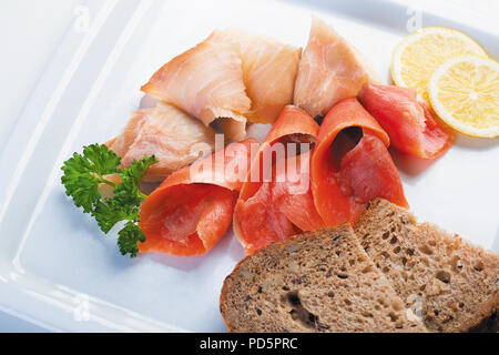 Mélange de rouge et blanc des morceaux de poisson salé sur une plaque blanche Banque D'Images