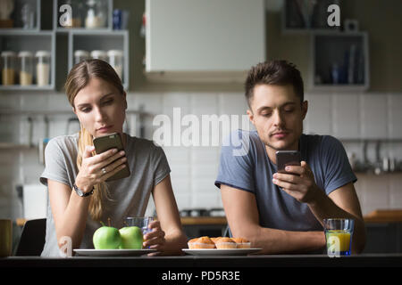 Couple millénaire obsédé par l'ignorant les smartphones Banque D'Images