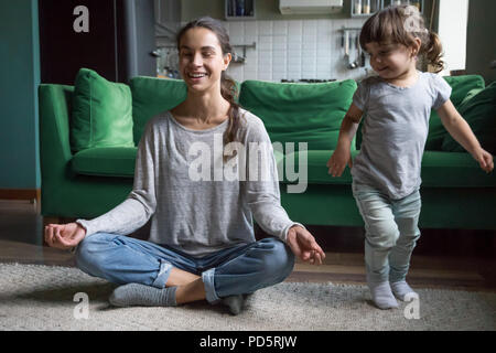 Professionnels attentifs mère faisant du yoga avec kid jouer à la maison Banque D'Images