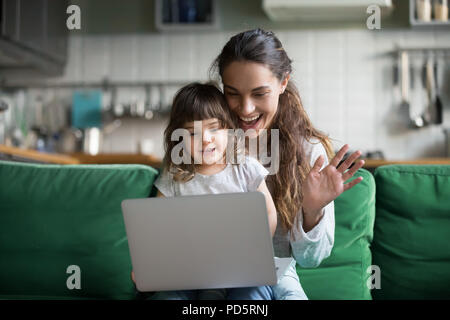 Mère et fille enfant heureux des signes avec la main faisant appel vidéo Banque D'Images