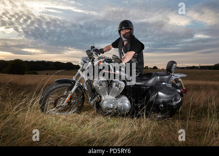 Vêtu de cuir biker posant pour une séance photo sur sa Harley Davidson XL883 Sportster Low cruiser moto, à l'Beverley Westwood, East Riding Banque D'Images