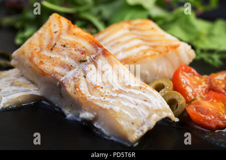 Filets de morue aux olives et câpres sur la plaque noire / cuisine Méditerranéenne Banque D'Images