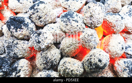 Un barbecue en plein air de charbons brûlés de camping. Arrière-plan coloré de charbon brûlé. Pot du charbon de bois prêt à mettre la viande sur le feu de barbecue grill. Banque D'Images