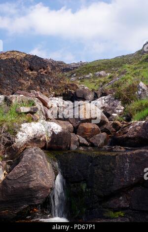 Brûler la montagne qui dévale à Diabaigas Torridonian Airde Loch à travers grès par le feu a brûlé les fougères. Torridon, Ecosse, Royaume-Uni. Banque D'Images