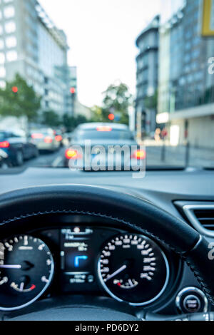 Concept shot of embouteillage dans la ville avec close-up de volant et floue de pilotage et rues avec voiture durant un ralentissement. Banque D'Images