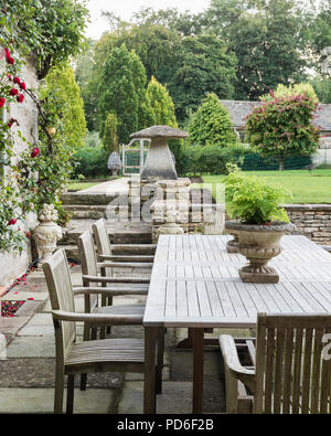 Table et chaises sur terrasse avec rosier grimpant Banque D'Images