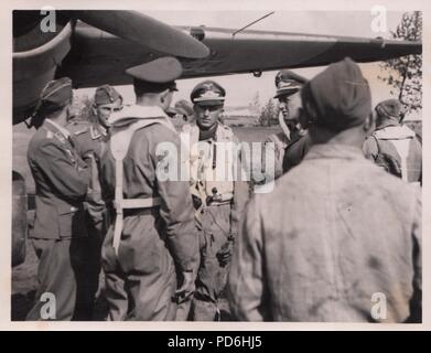 Droit de l'album photo de l'Oberleutnant Oscar Müller de la Kampfgeschwader 1 : l'Oberleutnant Friedrich Clodius (quatrième à partir de la gauche) en conversation avec l'équipage et le personnel au sol de 5./KG 1 à l'été 1941. Le lieutenant Oscar Müller est sur la gauche avec le dos à la caméra. Clodius est le Staffelkapitän du 5./KG 1 durant l'été 1941 et jusqu'à ce qu'il a été affiché le 8 novembre 1941 manquant. Banque D'Images