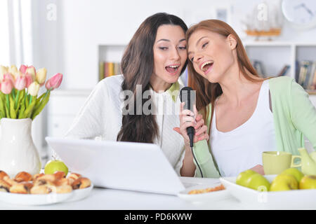 Portrait de deux jeunes femmes chantant karaoké Banque D'Images