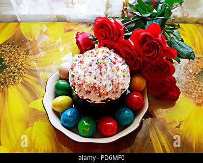 Vue de dessus de table de Pâques avec les oeufs de Pâques et de gâteau de Pâques autour avec magnifique bouquet de roses rouges Banque D'Images