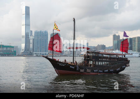 Aqualuna Croisière sur le port Victoria Harbour Passage Jonque Chinoise, Hong Kong. La ville de Kowloon à l'arrière-plan. Banque D'Images