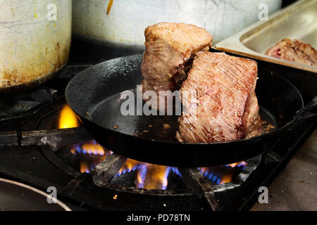 La cuisson des viandes sur cuisinière Banque D'Images