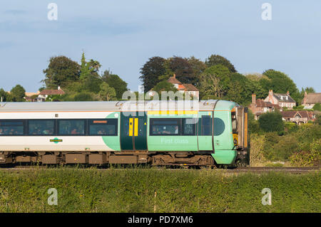 British Rail Class 377 Sud Electrostar train roulant à travers la campagne dans la lumière du soir à travers les South Downs dans le West Sussex, Royaume-Uni. Banque D'Images