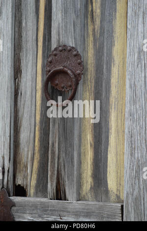 Close-up of cloutés rouillé sur heurtoir de porte en bois patiné Banque D'Images