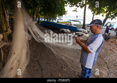 Les pêcheurs de la réparation de son filet de pêche sur la côte Pacifique, près de Mariato, Veraguas province, République du Panama. Banque D'Images