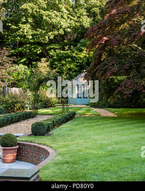 Neat country garden avec fort haie et maison d'été Banque D'Images