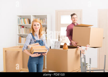 Happy young couple unpacking boxes dans leur nouvelle maison Banque D'Images