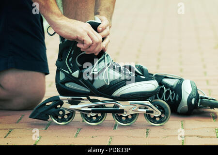 L'homme se préparer à roller, mise sur les rollers. Banque D'Images