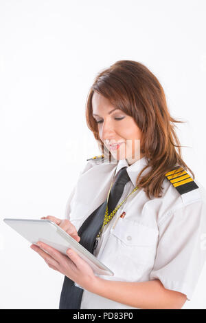 Belle femme pilote en uniforme avec des épaulettes holding tablet Banque D'Images