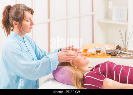 Guérisseur Reiki Reiki professionnel faire traitement de jeune femme Banque D'Images