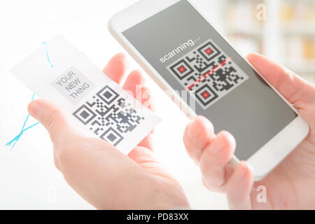 Femme code QR de l'analyse d'une étiquette dans un magasin de téléphonie mobile Banque D'Images