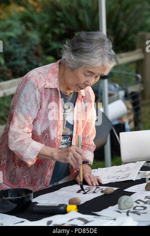 Seattle, Washington : un calligraphe japonais écrit un message sur une lanterne de papier pour la Toro Nagashi flottante lanterne cérémonie en souvenir des victimes de la bombe atomique sur l'anniversaire du bombardement de Hiroshima, au Japon. La cérémonie annuelle flottante lanterne honore les victimes des bombardements d'Hiroshima et Nagasaki, et toutes les victimes de la violence. Crédit : Paul Christian Gordon/Alamy Live News Banque D'Images