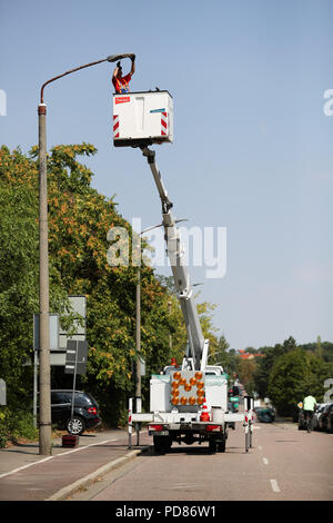 Halle, Allemagne. 07Th Aug 2018. 08/07/2018 La Saxe-anhalt, Halle (Saale) : Michael Conrad installe un nouveau luminaire LED pour l'éclairage des rues. Stadtwerke Halle installé le millième conduit lampe de rue le même jour. Les 23 400 appareils dans la zone de la ville sont peu à peu transformé en un éclairage moderne. Appareils à LED consomment moins d'électricité, ont un meilleur rendement lumineux et score avec une agréable lumière-couleur par rapport à l'habituel des lampes à vapeur de sodium. Crédit : Jan Woitas/dpa-Zentralbild/dpa/Alamy Live News Banque D'Images