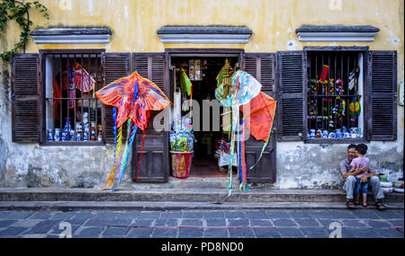 EDitorial : Aug 5, 2017, l'ancienne ville de Hoi An, Vietnam. Un magasin en Anicent Ville Hoi An avec un père et un enfant assis sur un trottoir. Banque D'Images