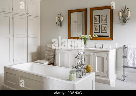 Vintage bougeoirs de mur au-dessus du bassin double classique dans une salle de bains privative avec baignoire sur pieds panneaux Banque D'Images