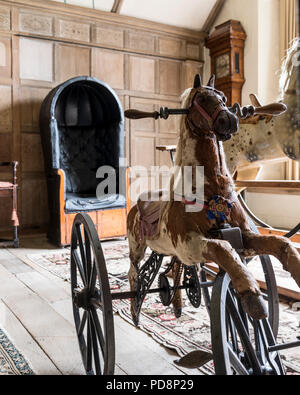Cheval à bascule ancien et chaise en cuir noir dans la salle lambrissée Banque D'Images