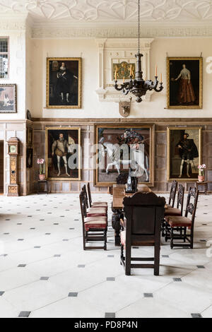 Une salle de réception spacieuse avec table, chaises et d'art encadrées Banque D'Images