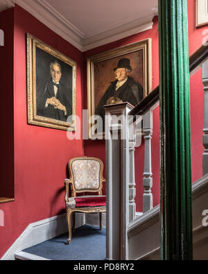 Portraits encadrés sur mur d'escalier rouge Sketch Club de Londres Banque D'Images