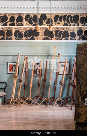 Une pile de chevalets dans la salle du Sketch Club de Londres. Les silhouettes des anciens membres ornent le mur au-dessus Banque D'Images