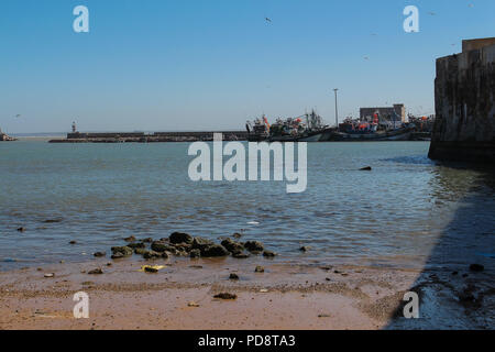 Vue de la plage bordant l'ancienne forteresse portugaise. De l'eau de l'océan Atlantique. Mur de forteresse sur le côté droit. Port avec les bateaux sur l'hor Banque D'Images