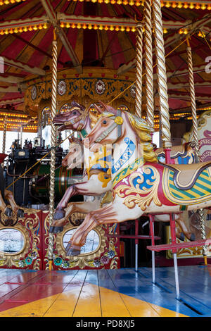 Cheval au galop à vapeur carrousel, fairground ride à un bain à vapeur juste. L'Angleterre Banque D'Images