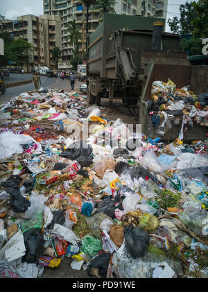Des sacs en plastique remplis de déchets ménagers se trouvent sur rue à côté de poubelle à Mumbai, Inde