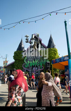 Southend on Sea, Essex. L'île Adventure fun fair. Un groupe de femmes musulmanes à pied passé attraction Spooksville Banque D'Images