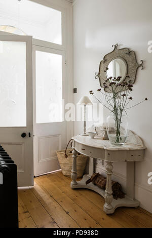 Table console recouvert de marbre blanc en entrée avec du parquet. Banque D'Images