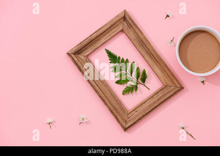 Minimaliste à la main, décor intérieur botanique tropical vert feuilles dans des cadres en bois accroché sur fond rose Banque D'Images